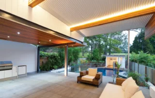 Low-pitch insulated patio roofing over a contemporary outdoor living area